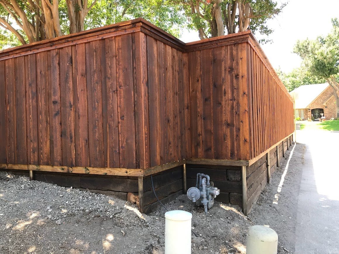 Rustic railroad tie retaining wall along a sloped yard